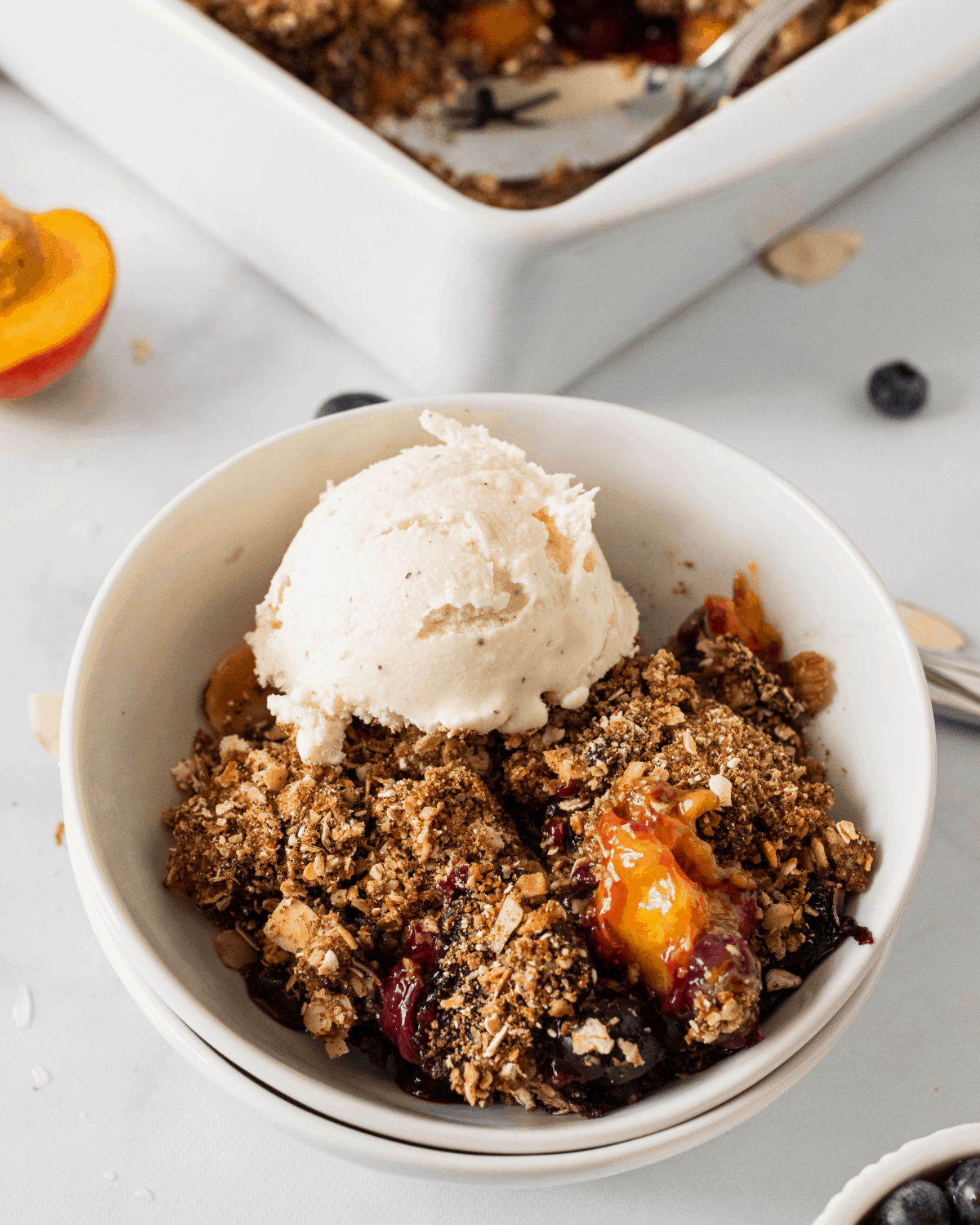 peach blueberry crisp with vanilla ice cream on top.