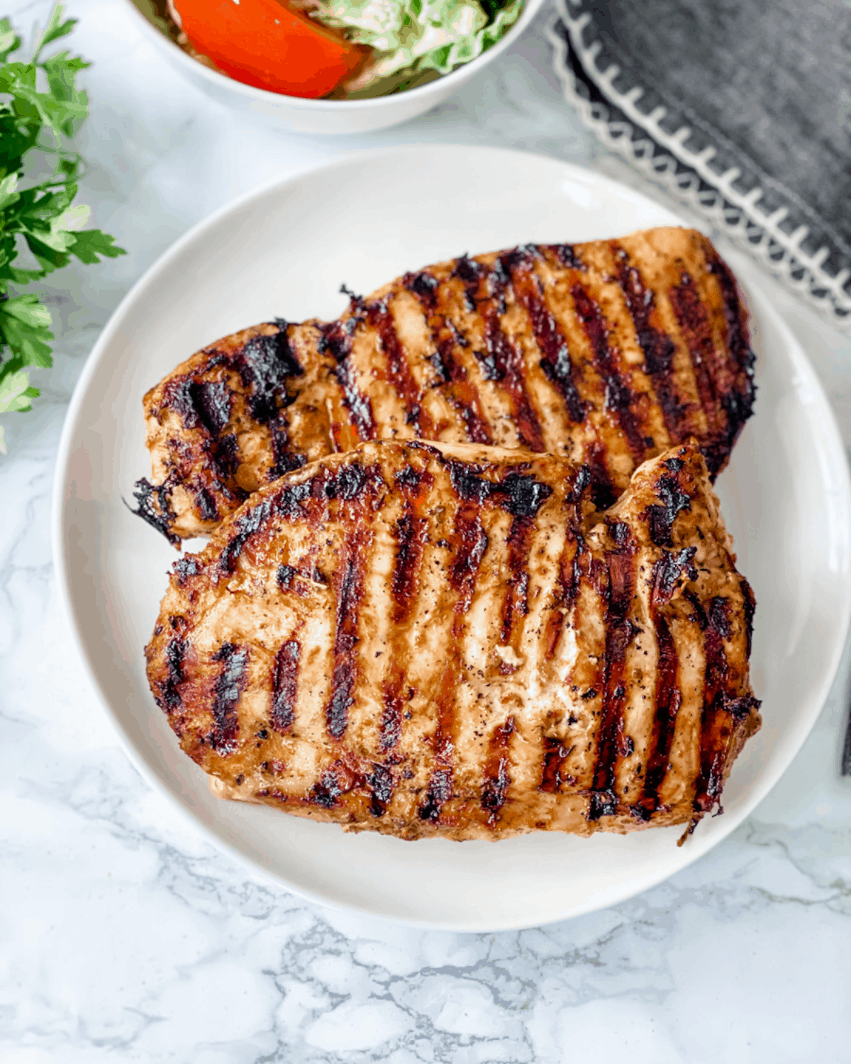 two pieces of grilled chicken on a plate