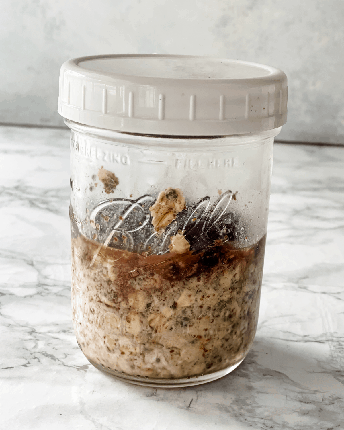 The ingredients for cherry overnight oats in a jar.