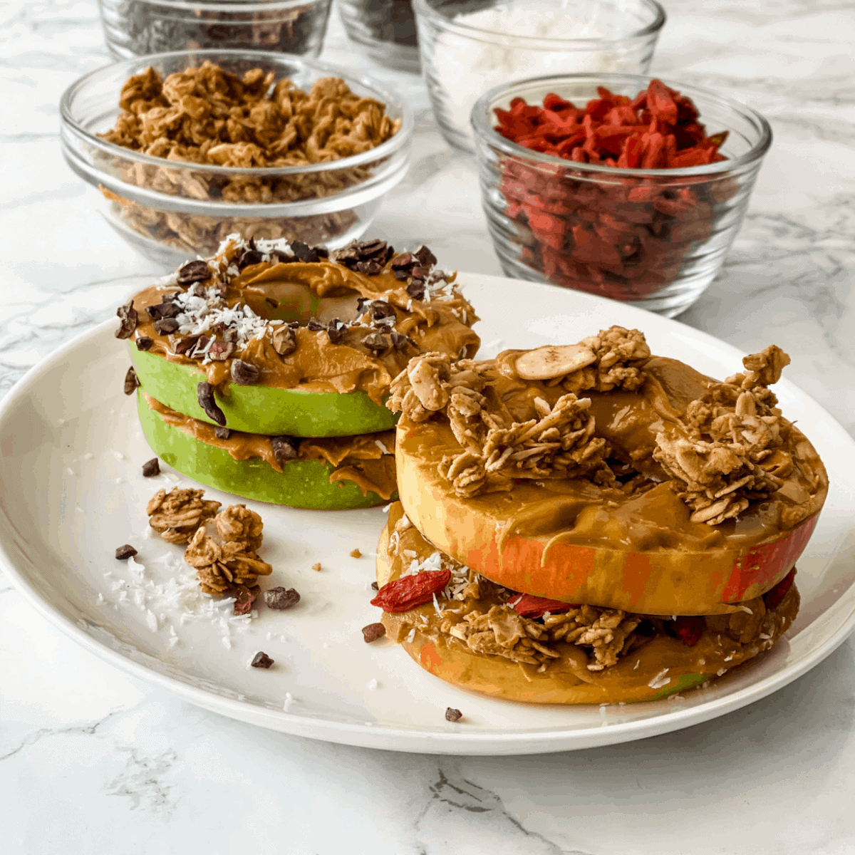 apple sandwich with peanut butter, granola, and other toppings