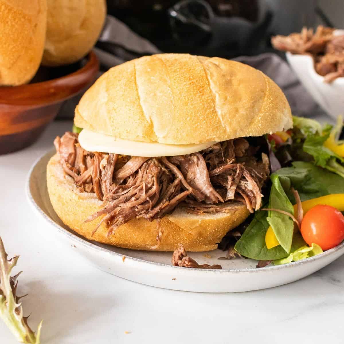 Slow cooker pot roast with onion soup mix shredded and on a roll