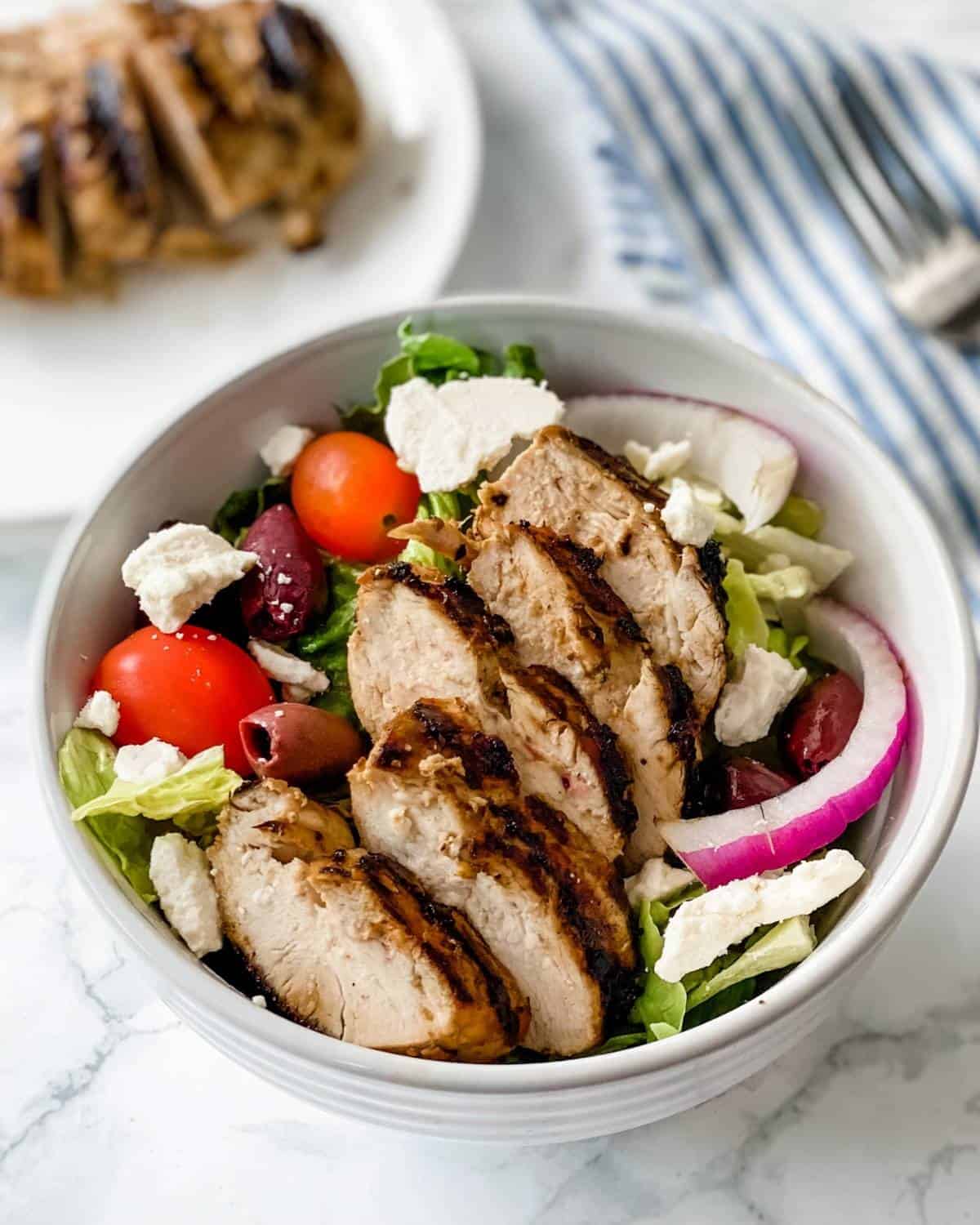 grilled greek marinated chicken on a salad