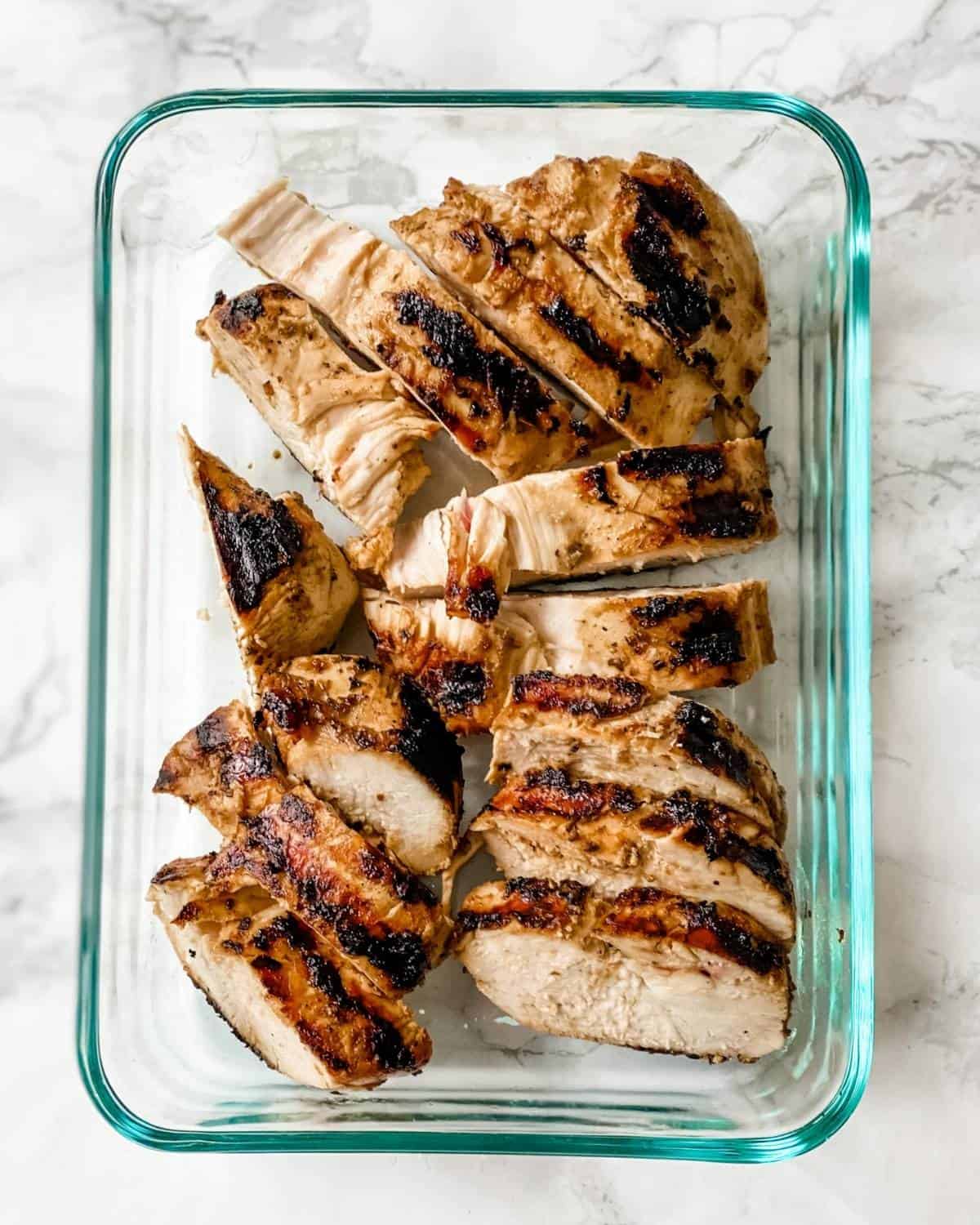 cooked grilled chicken in a glass container
