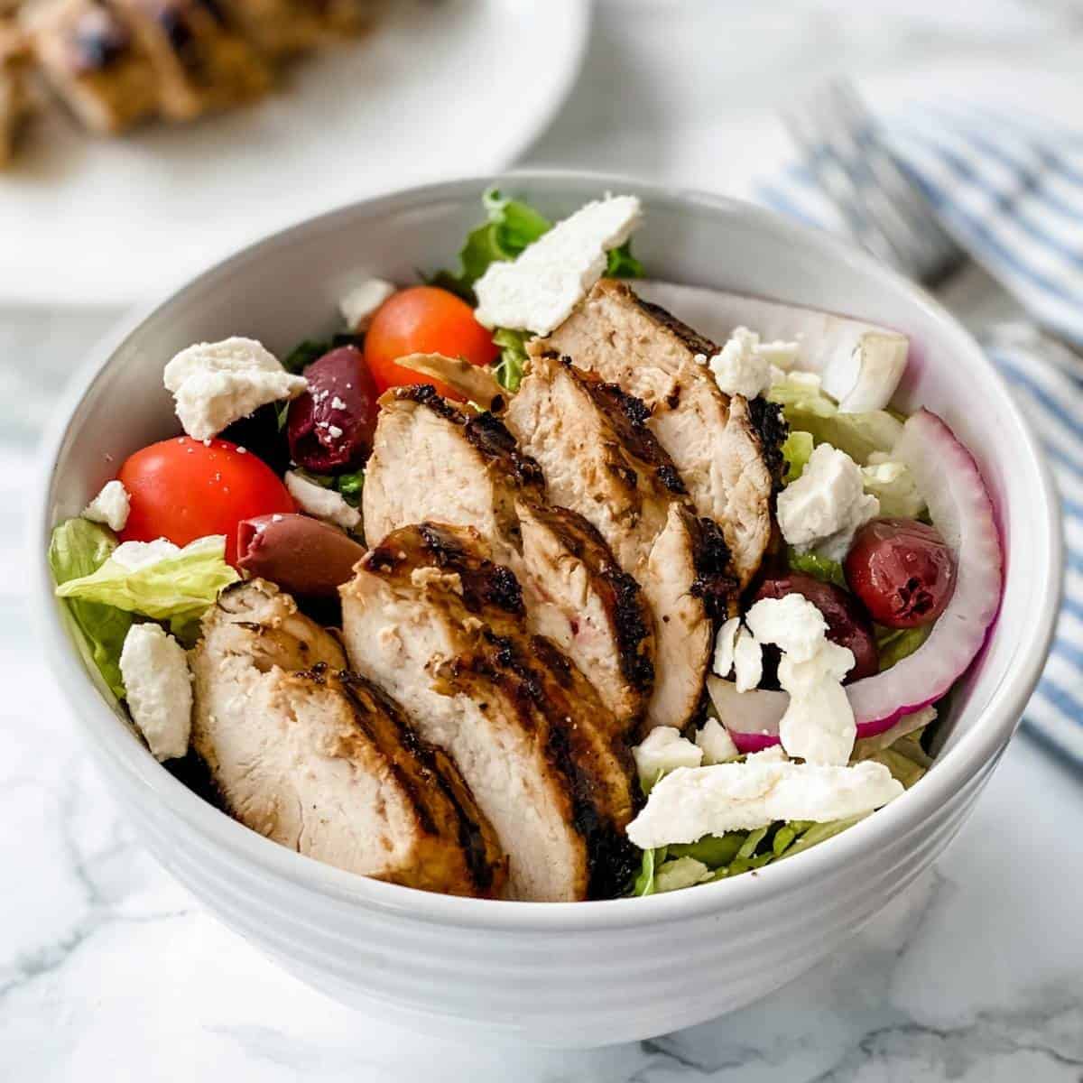 greek chicken marinade on a Greek Salad in a bowl