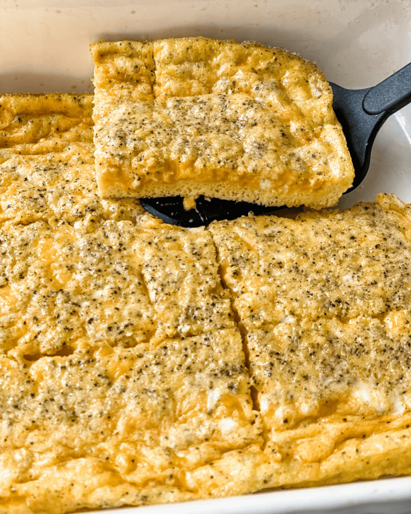 close-up view of a piece of the egg baked lifted from the casserole dish.