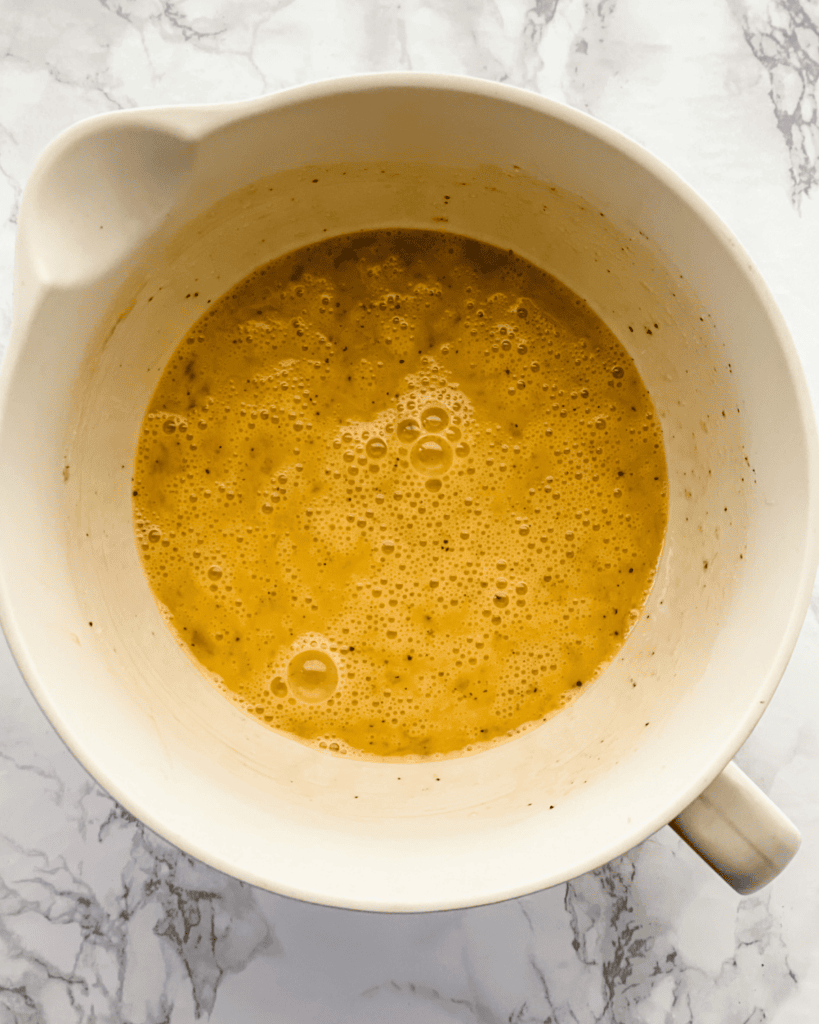 eggs and seasoning mixed into a bowl.
