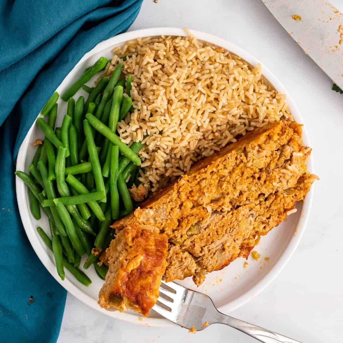 the best healthy meatloaf sides. meatloaf, rice, and green beans on a plate.