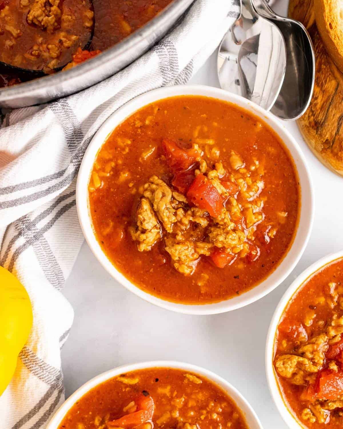 bowls of stuffed pepper soup next to the pot of soup