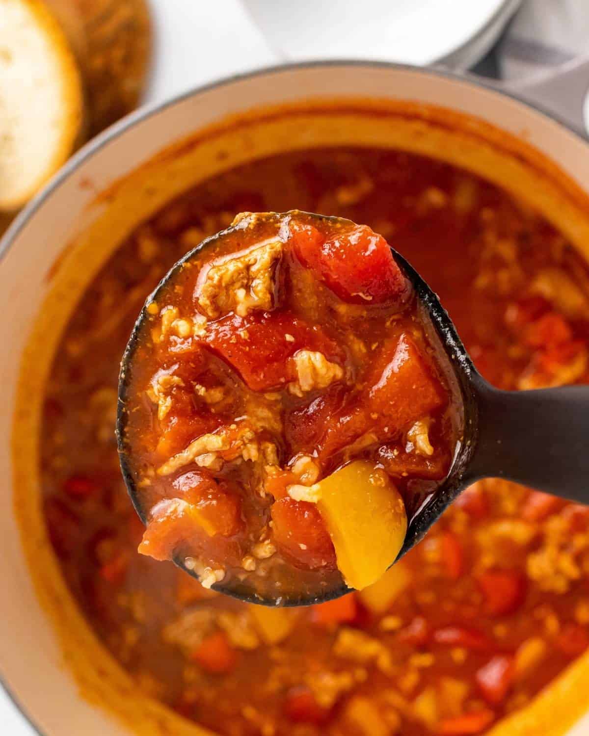 close up picture of stuffed pepper soup in a soup ladle