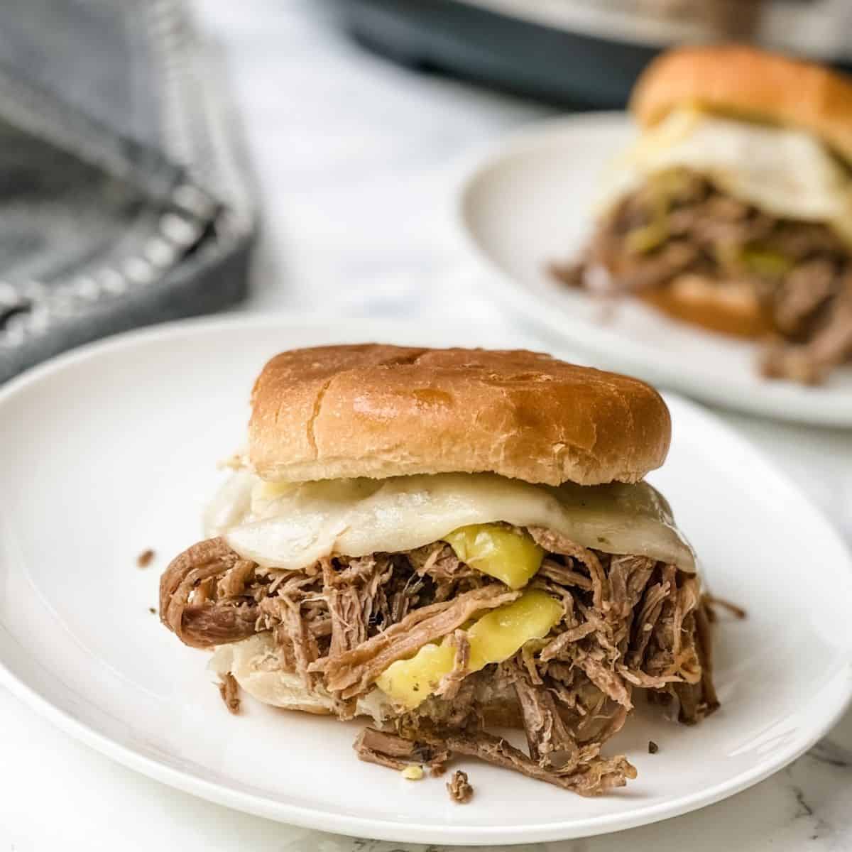 Italian beef on a sandwich bun on a plate.