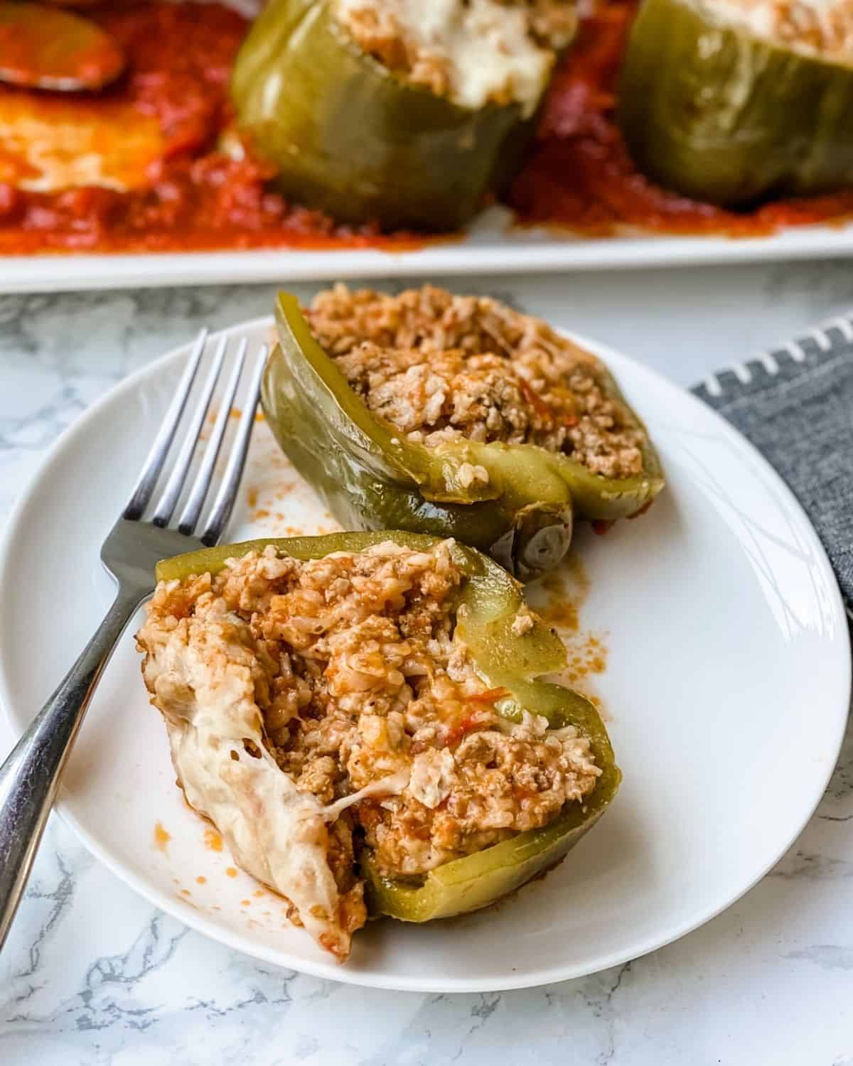 italian stuffed pepper cut in half on a plate.