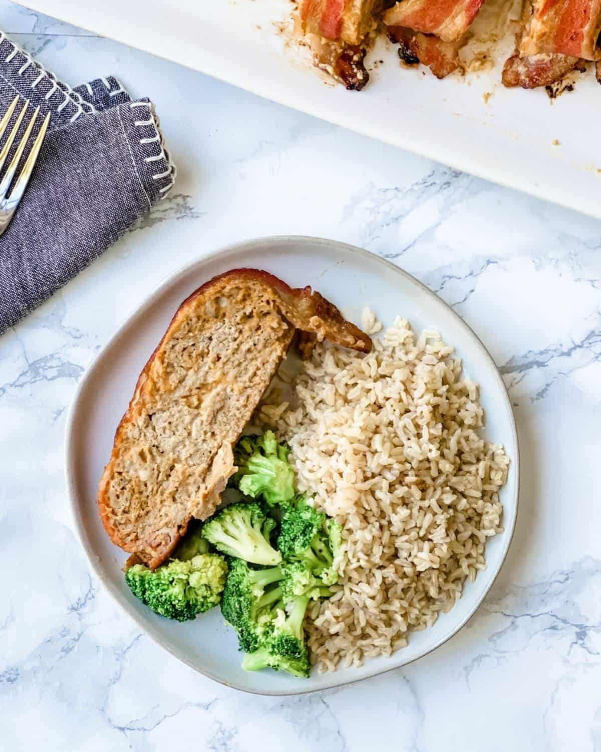 The cheeseburger patties overhead are placed on a plate, with rice and broccoli on top.