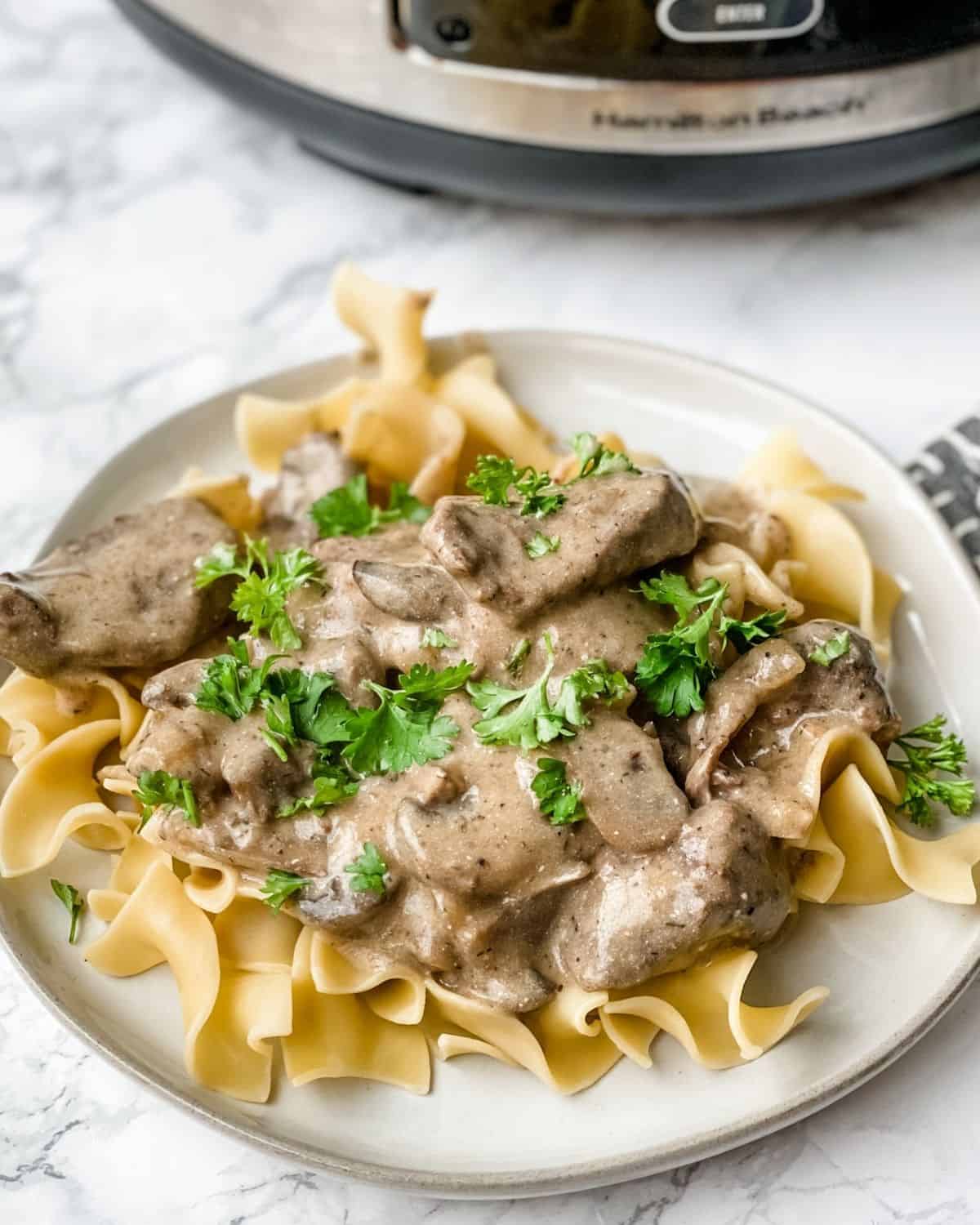 closeup picture of beef stroganoff sprinkled with parsley.