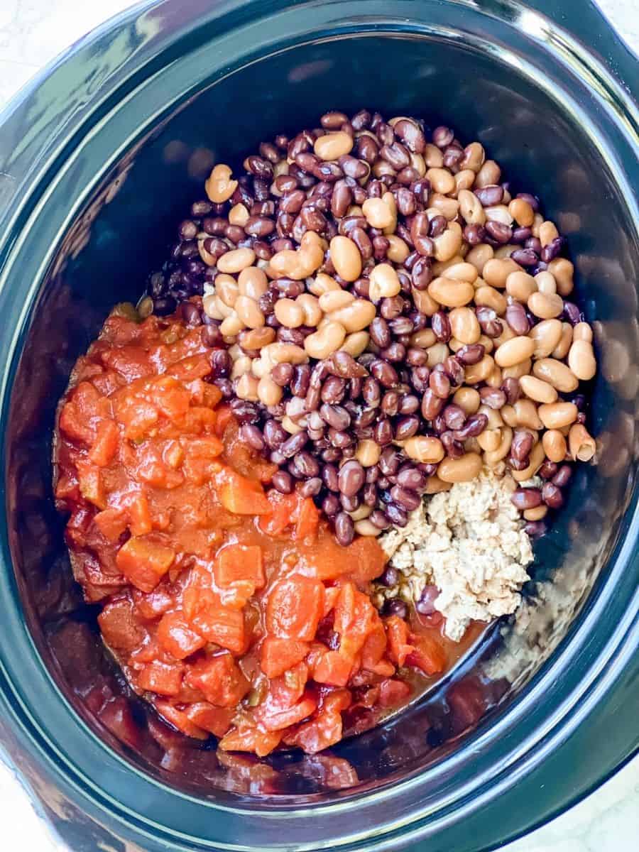 beans, diced tomatoes, and onion mixture in slow cooker with meat