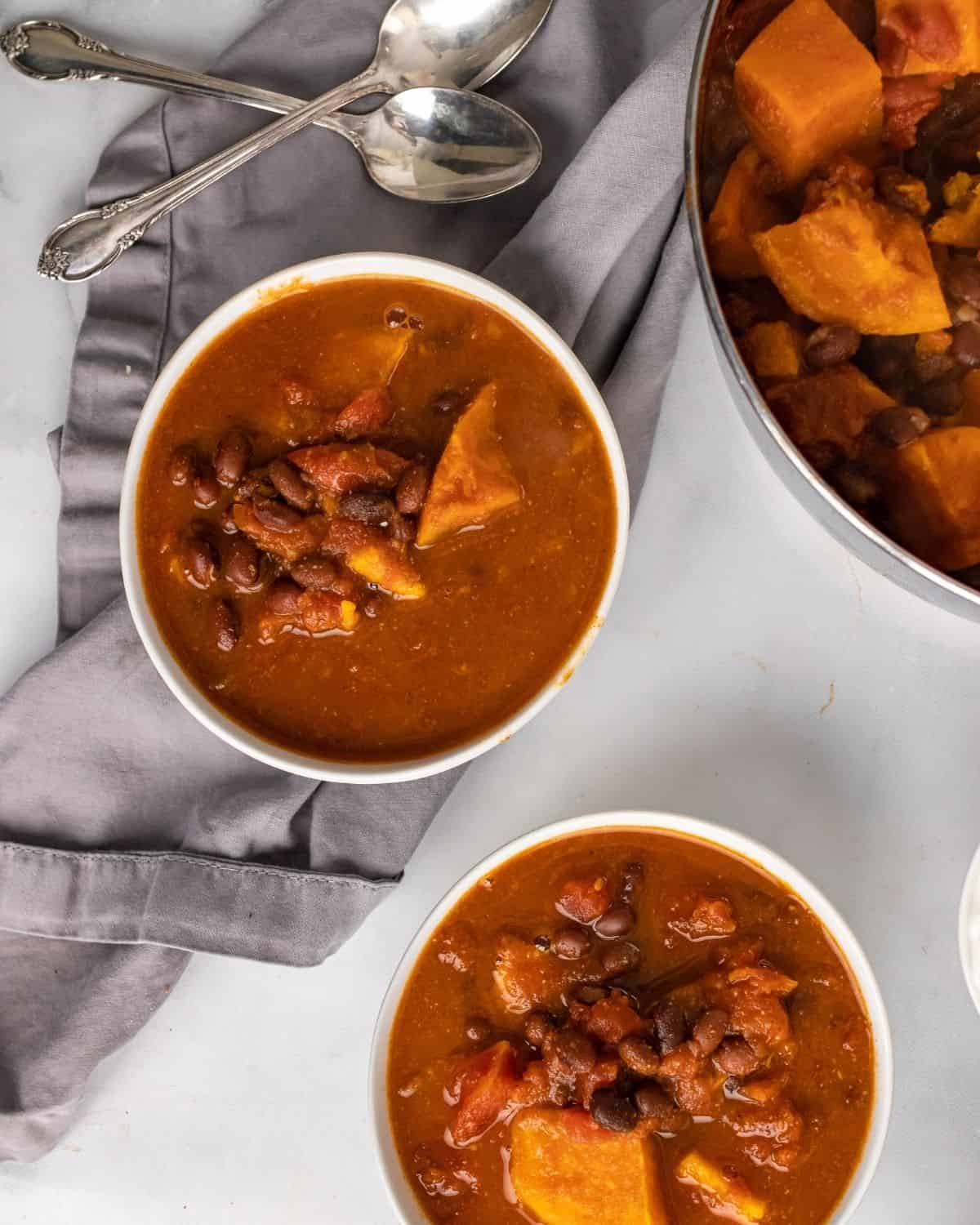 Overhead photo of sweet potato and black bean soup in a bowl and soup pot.