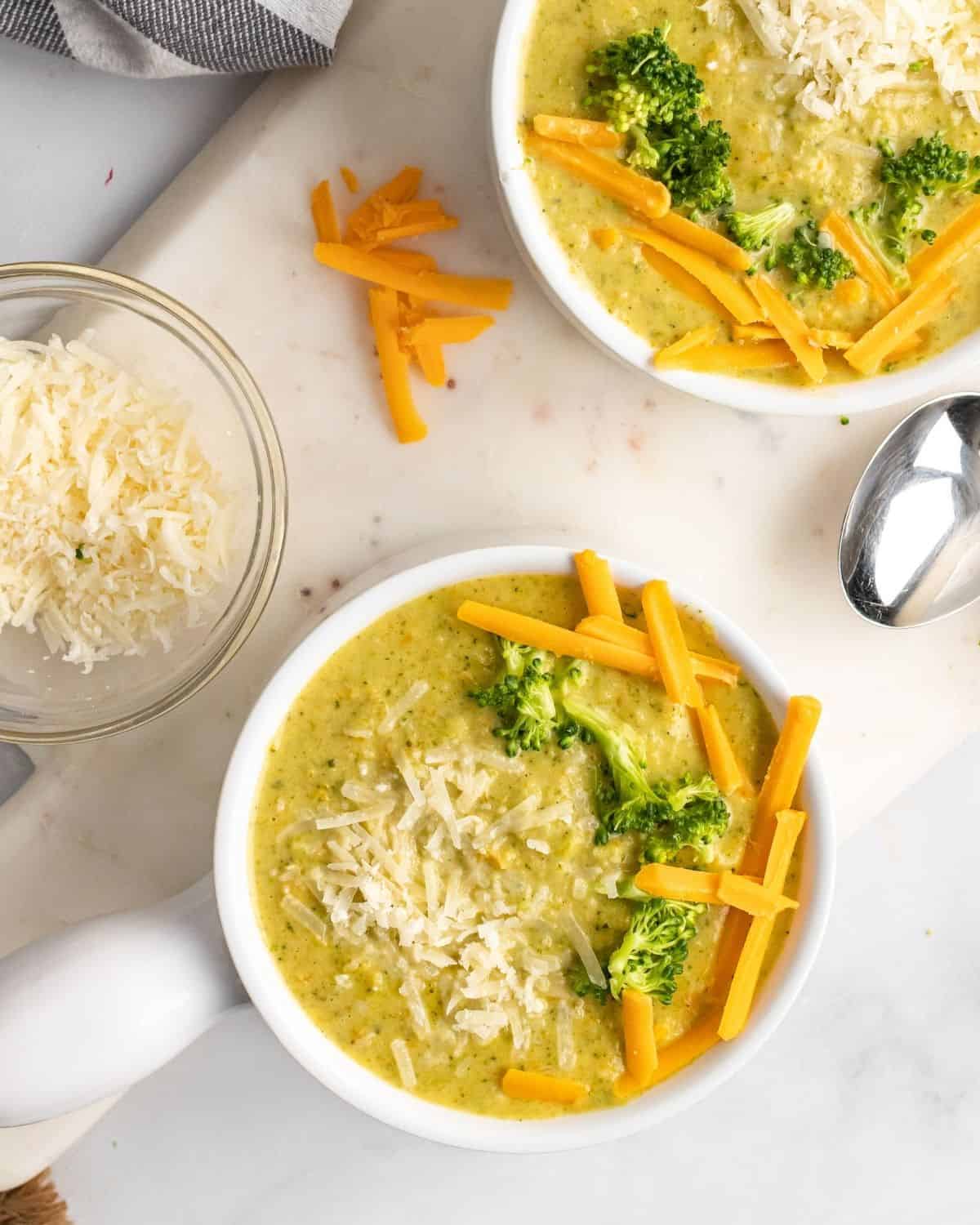 overhead picture of the broccoli cheese soup with cheese and broccoli on top.