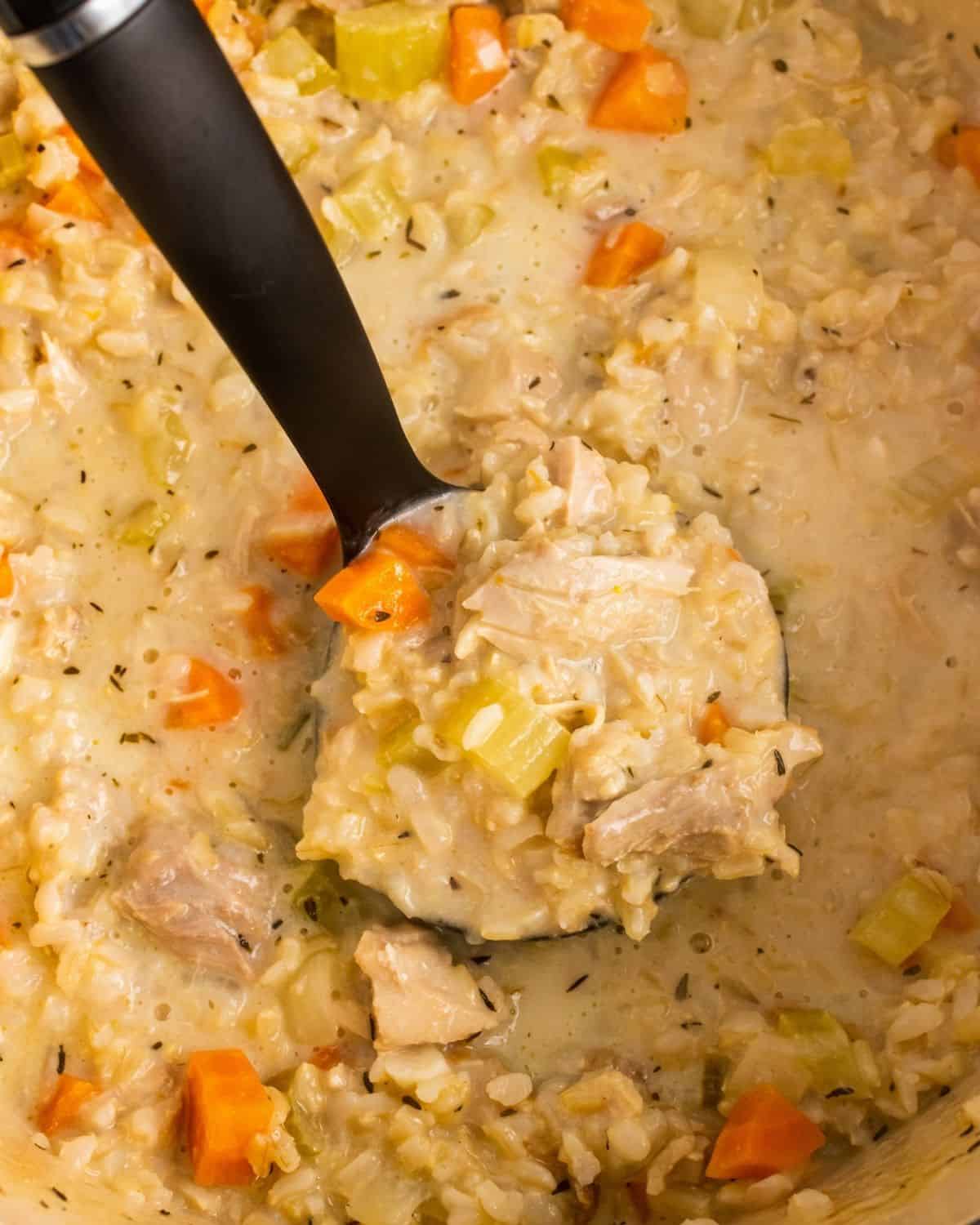 Overhead picture of the soup in a ladle over the soup pot
