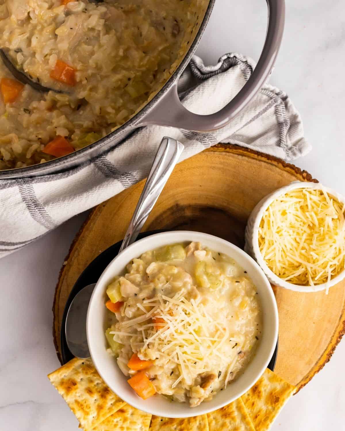 chicken and rice soup in a bowl next to the soup pot