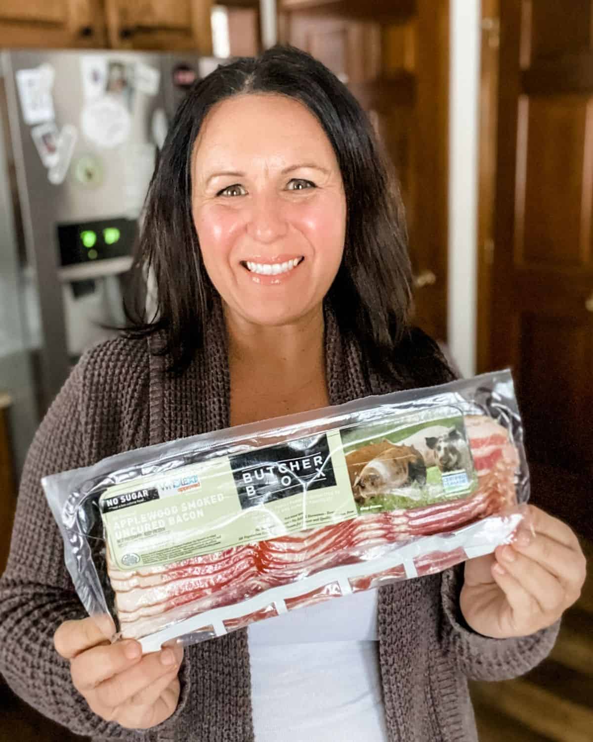 Tammy Overhoff holding a package of butcher box bacon.