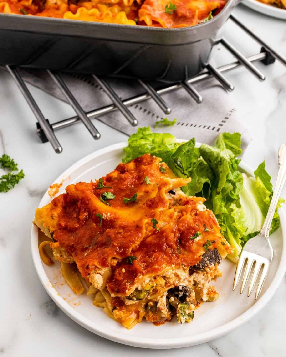Vegetable lasagna on a plate with a fork.