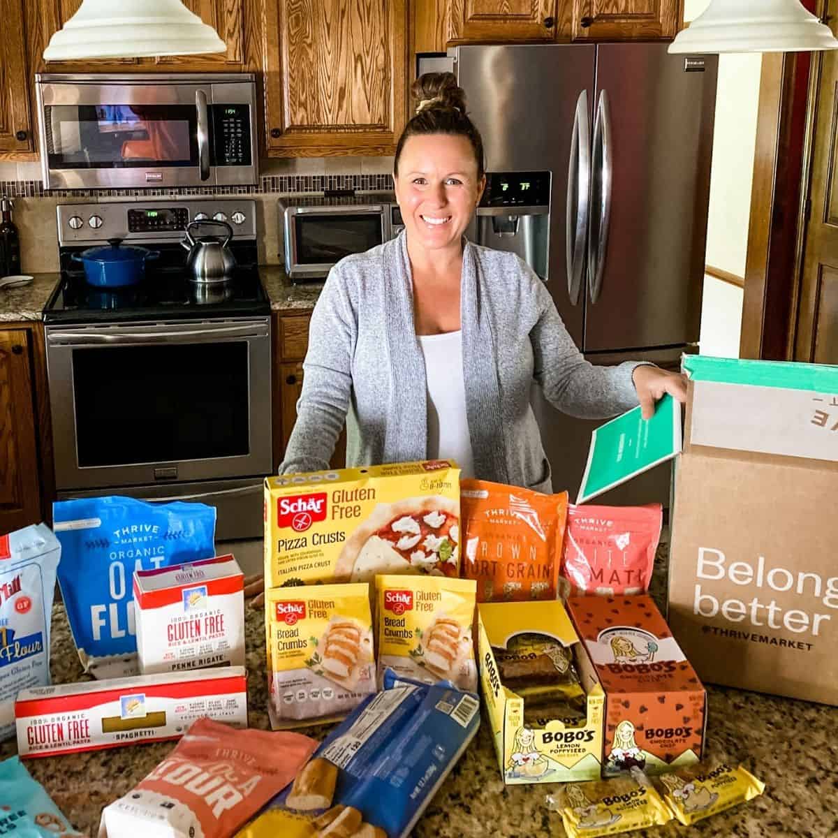Tammy Overhoff in front of a Thrive Market box with all of the food items she ordered.