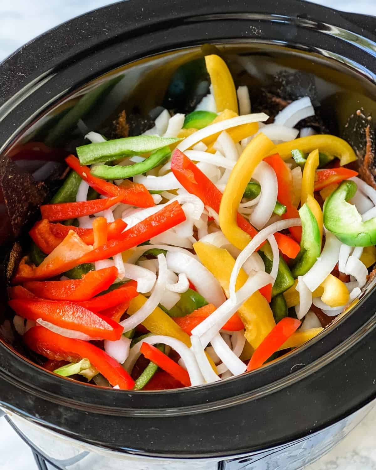 Chicken fajita recipe ingredients layered into a crockpot