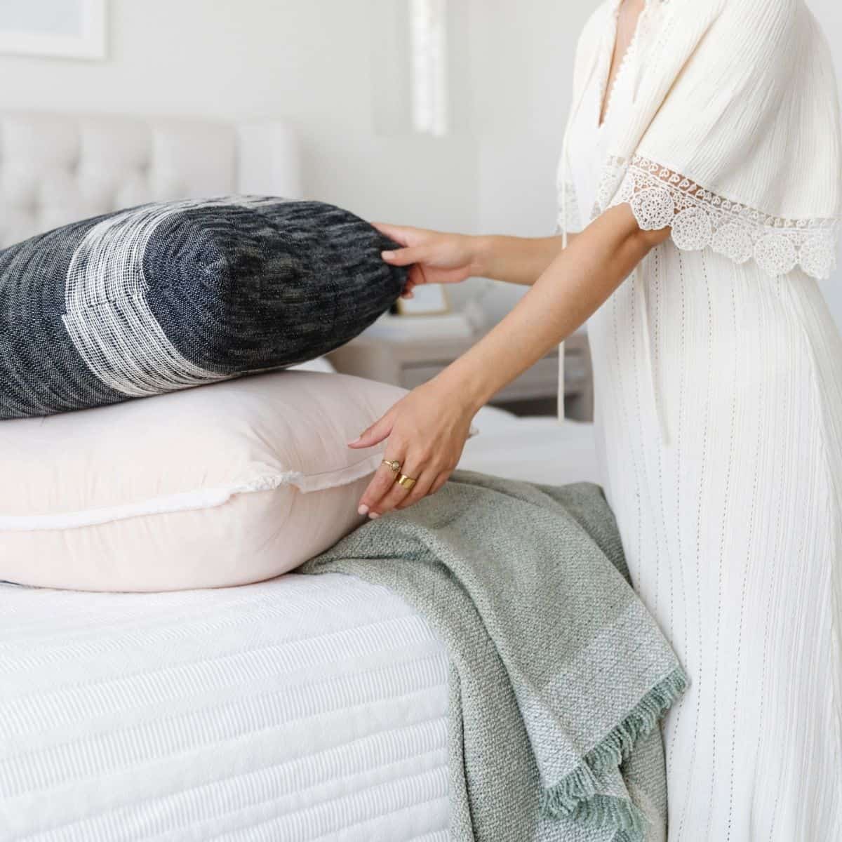 woman with pillows making the bed