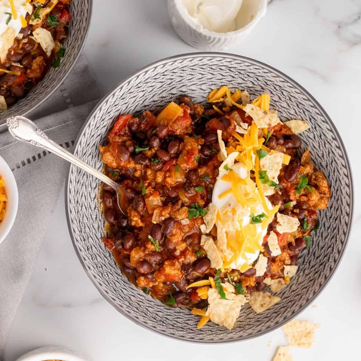 vegetarian chili recipe in a bowl with sour cream and tortilla chips