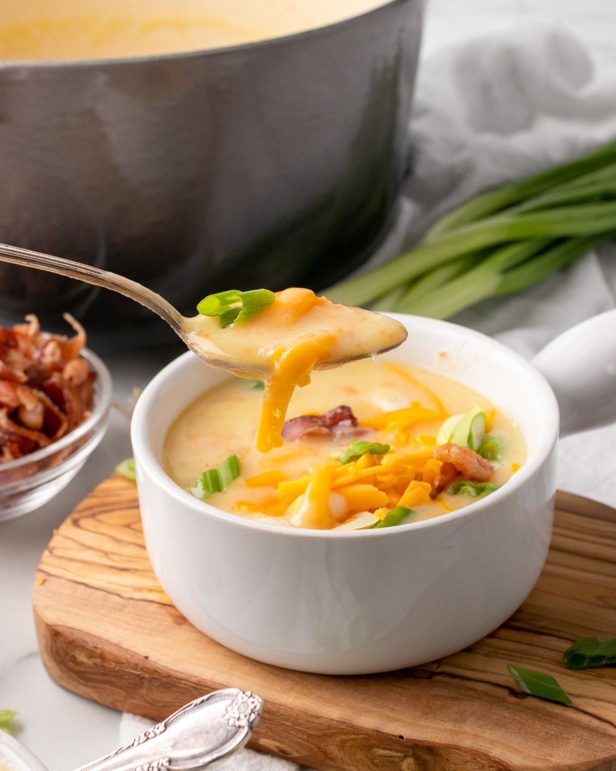 close up of healthy potato soup in a bowl with a spoonful showing the creaminess.