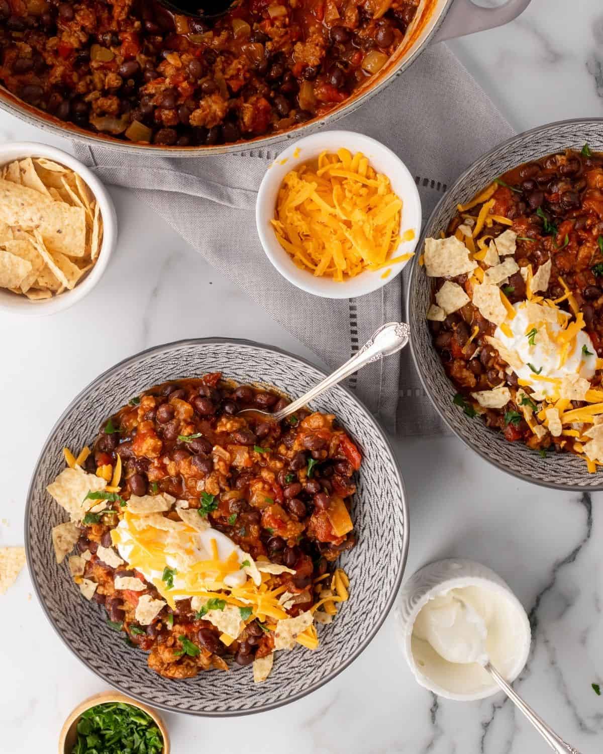 overhead picture of vegetarian chili in bowls next to the soup pot.