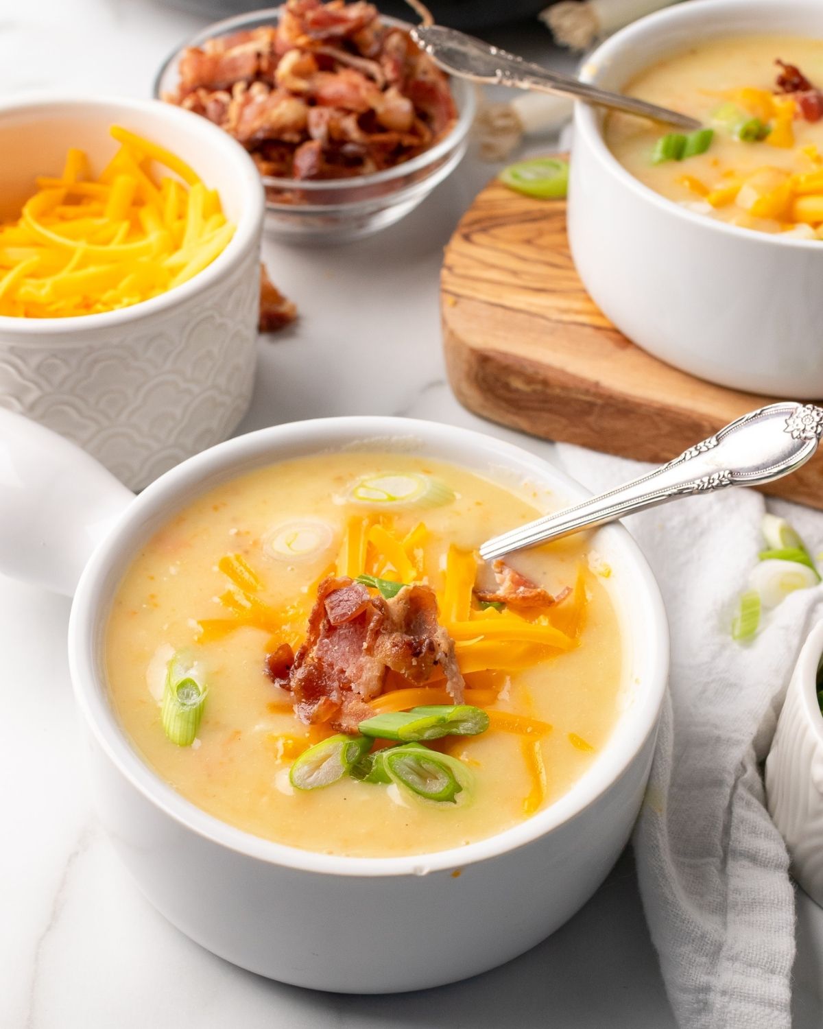 creamy light potato soup in a bowl with a spoon in it