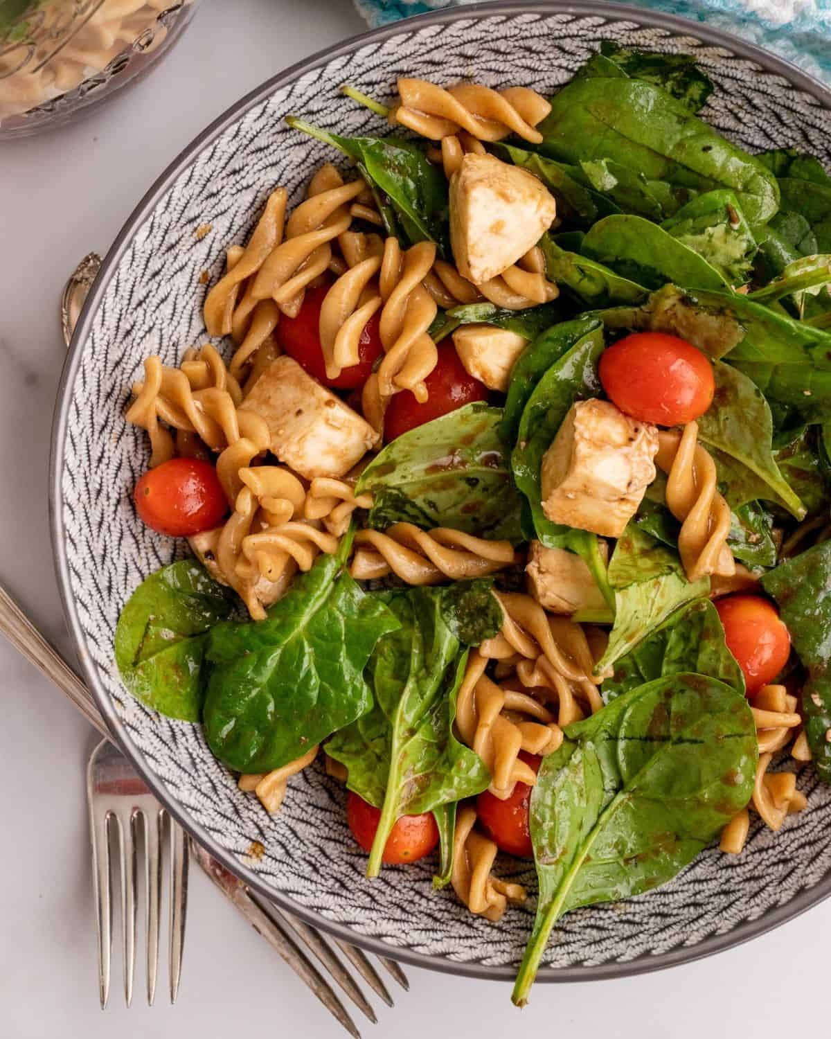spinach pasta salad in a bowl.