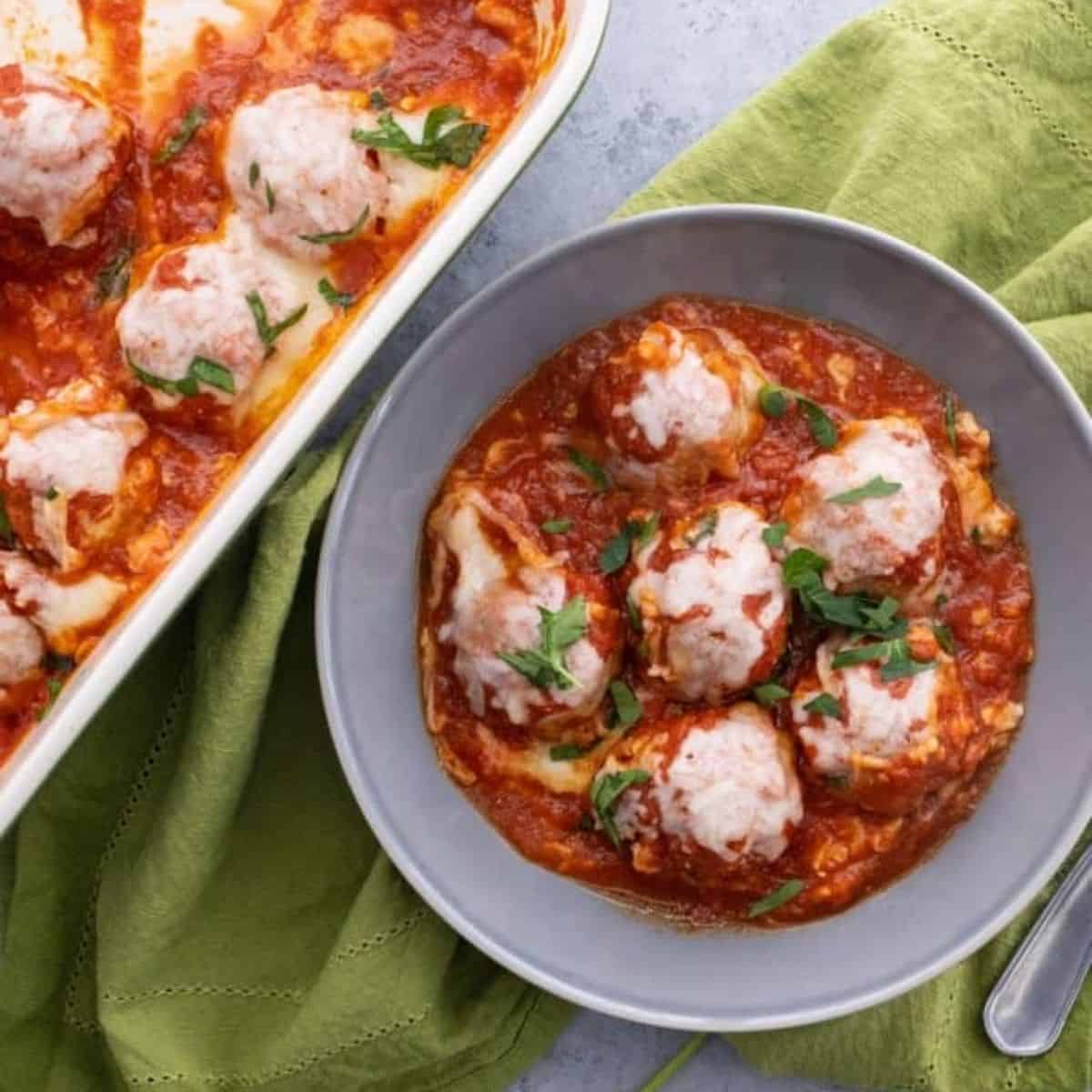 chicken meatball parmesan in a bowl next to the pan.