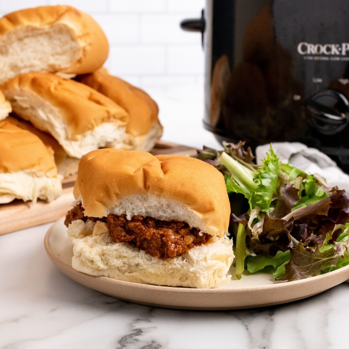 slow cooker sloppy joes on a plate with salad