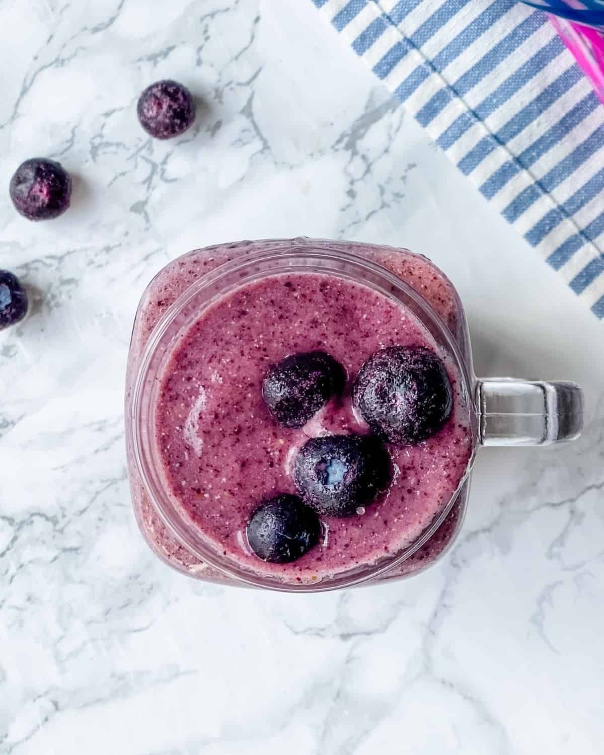 overhead picture of a blueberry smoothie in a mason jar.