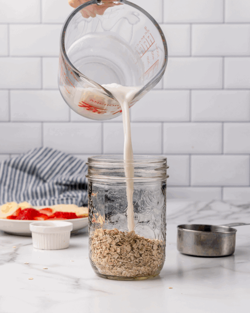 milk to rolled oats and chia seeds in a mason jar.
