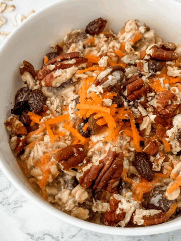 close-up view of carrot cake overnight oats in a white bowl