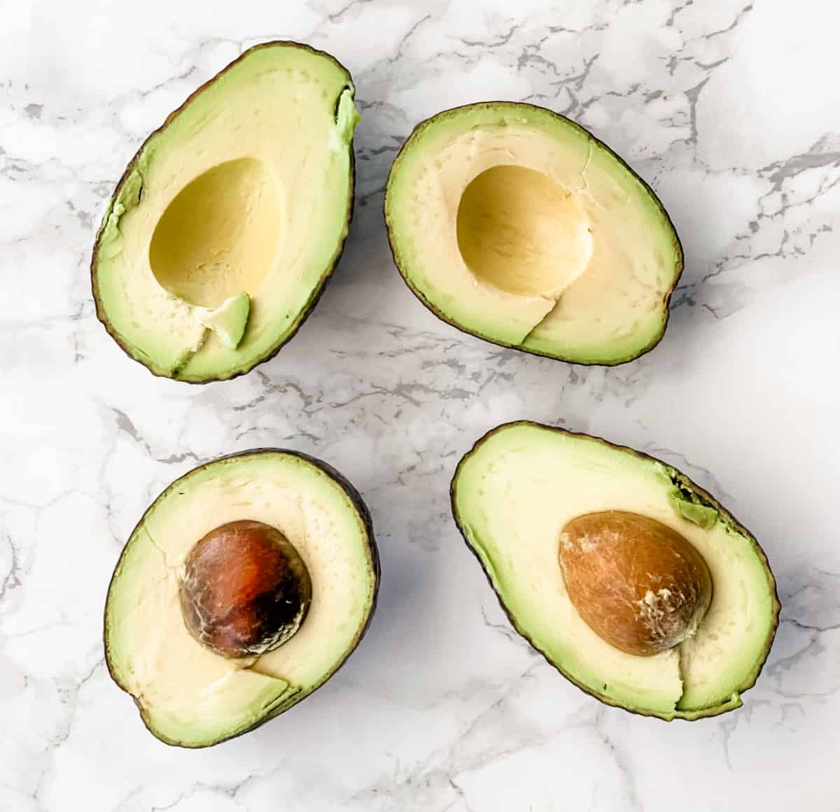 avocados cut in half with flesh facing up.