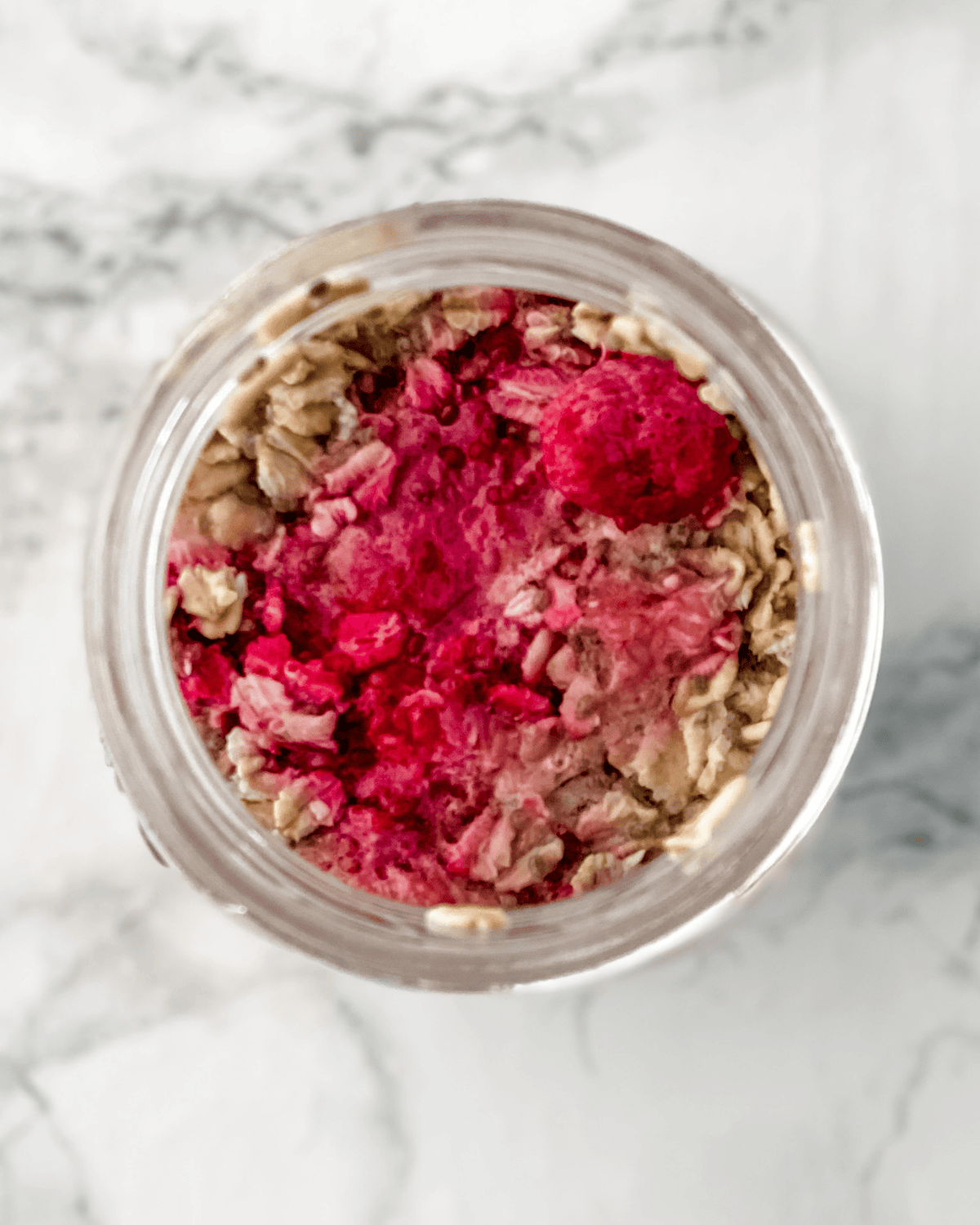 raspberry overnight oats thicked in a jar.