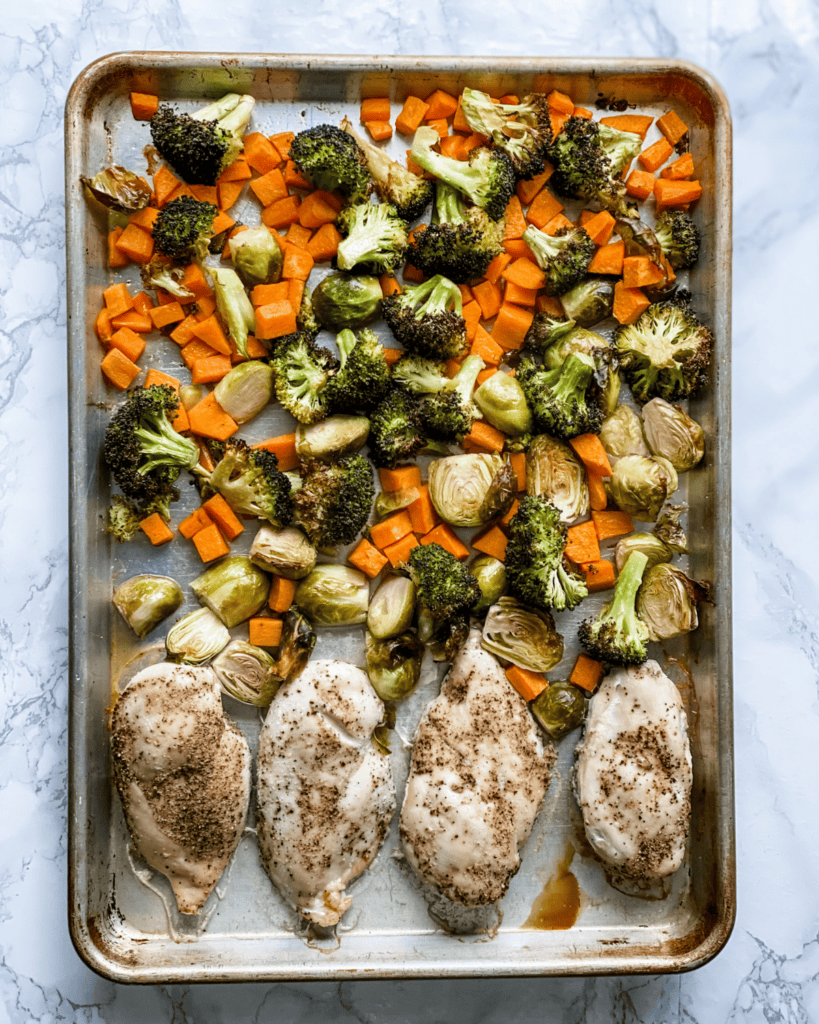 Cooked chicken and veggies on a sheet pan.