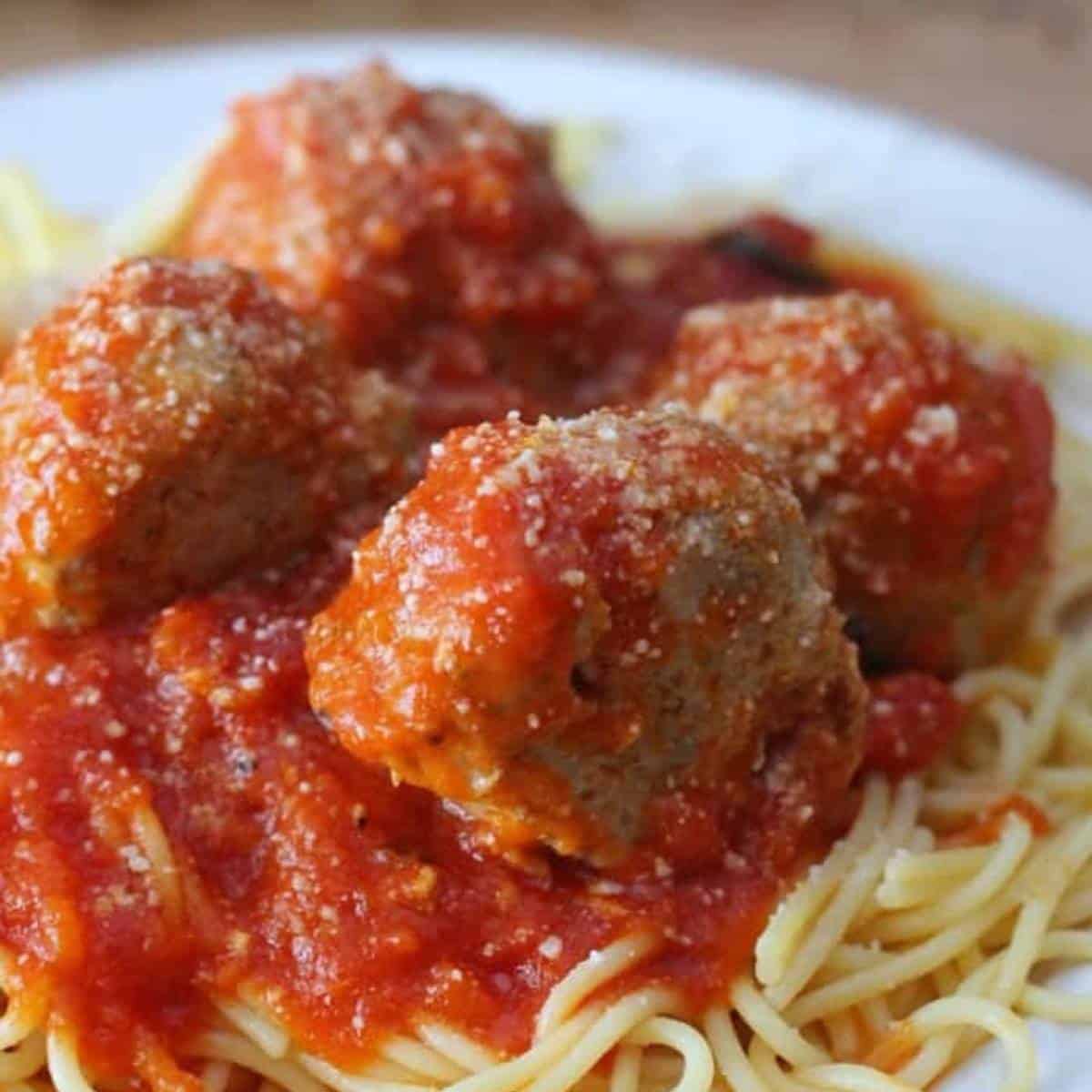 turkey meatballs with sauce on pasta on a plate.