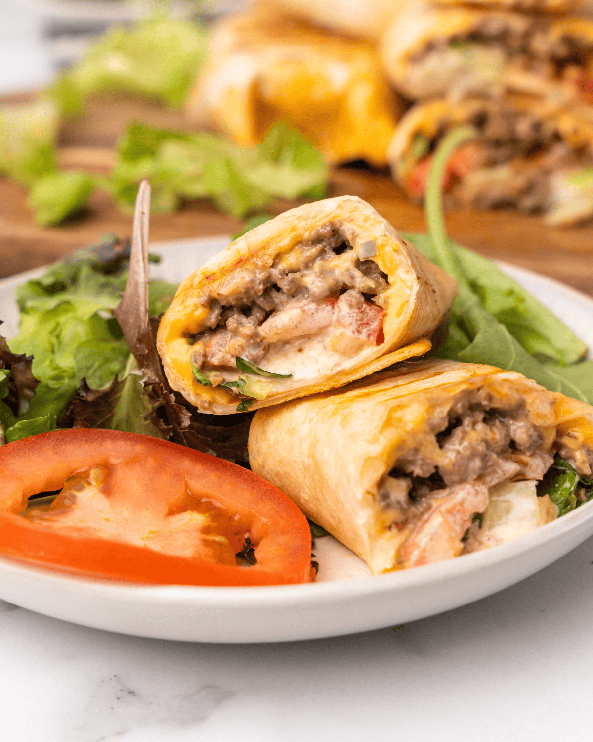 burger wrap on a plate with salad.