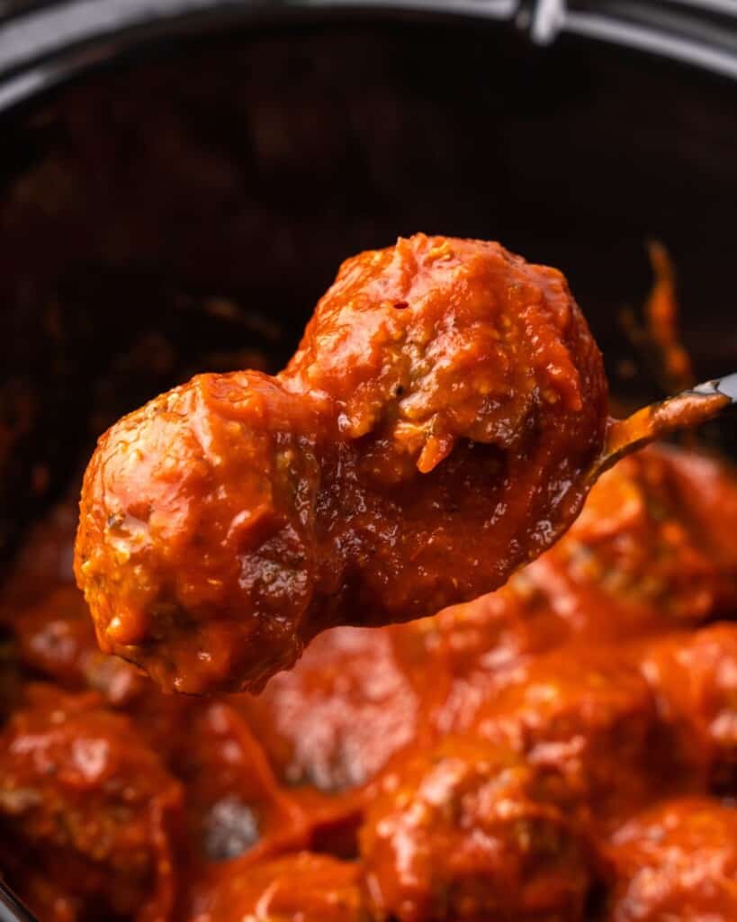 meatballs on a spoon coming out of crockpot.