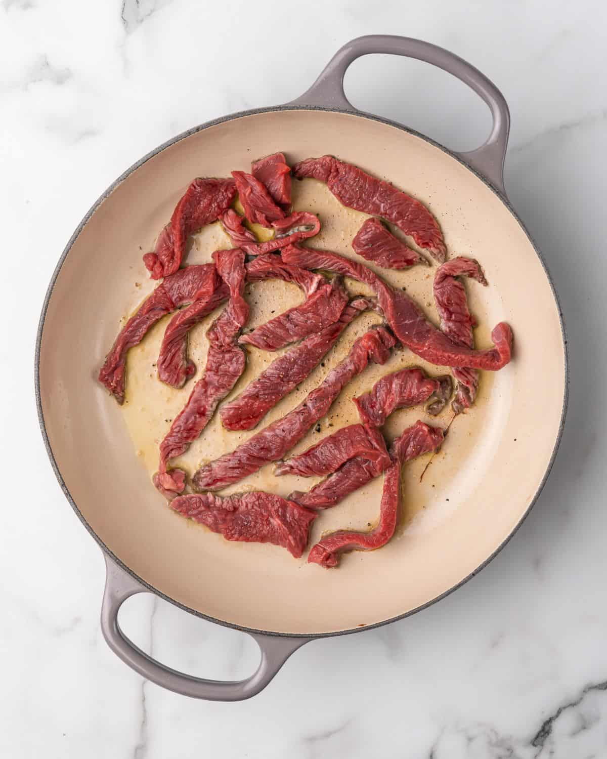 seasoning beef cooking in a pot