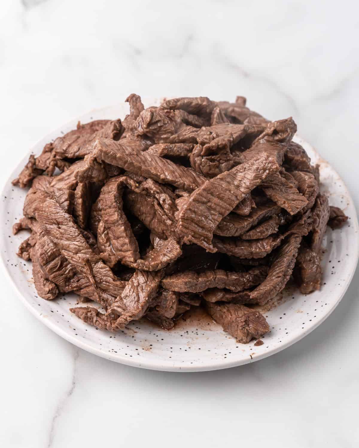 cooked beef strips on a plate.