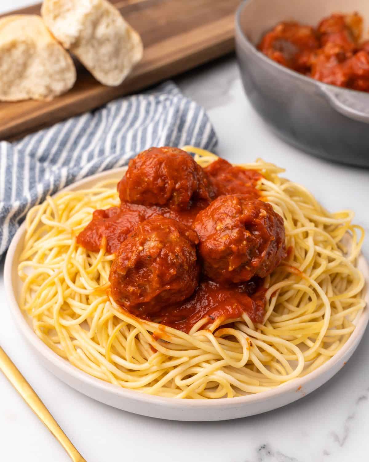 turkey meatballs in sauce on pasta on a plate.