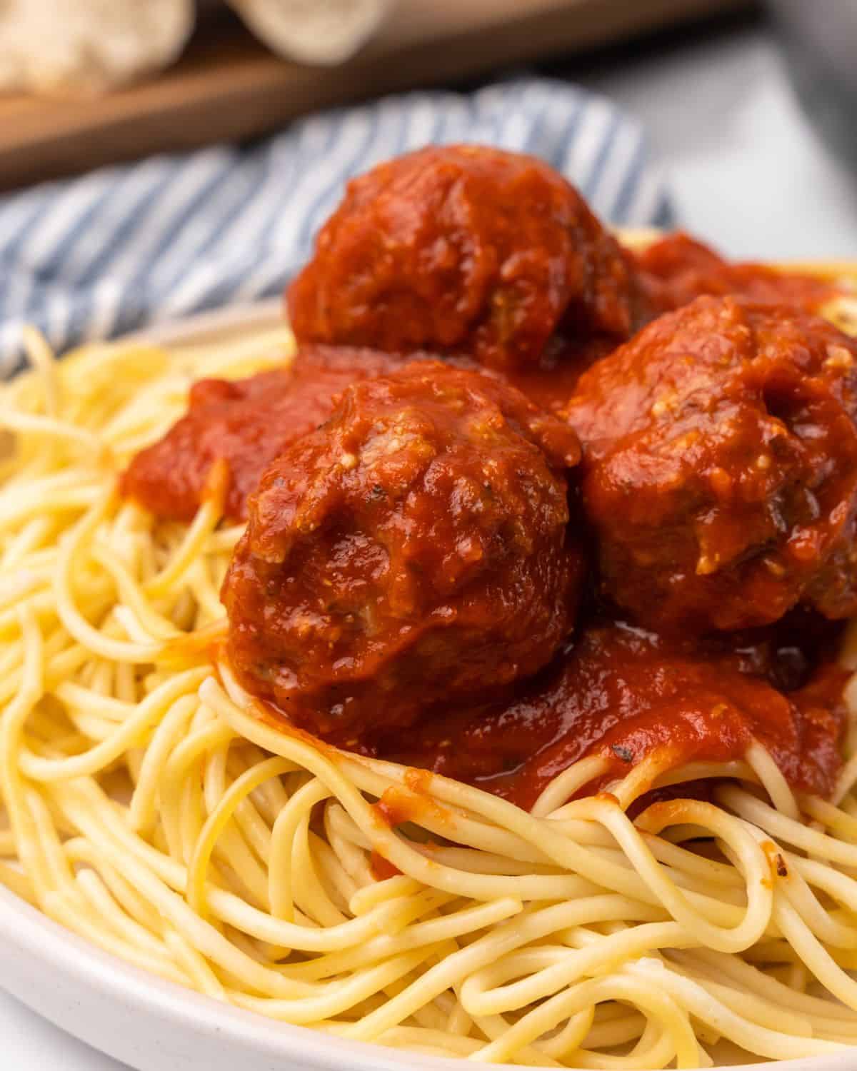closeup picture of turkey meatballs on pasta with sauce.
