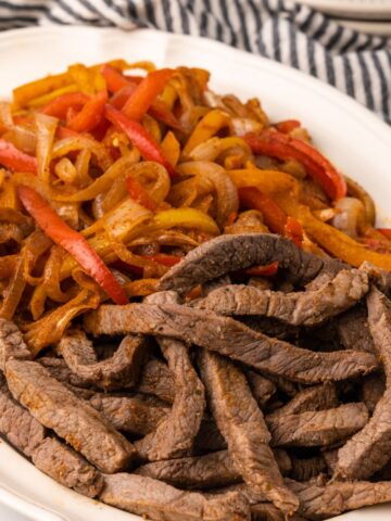 overhead picture of steak fajitas on a platter.