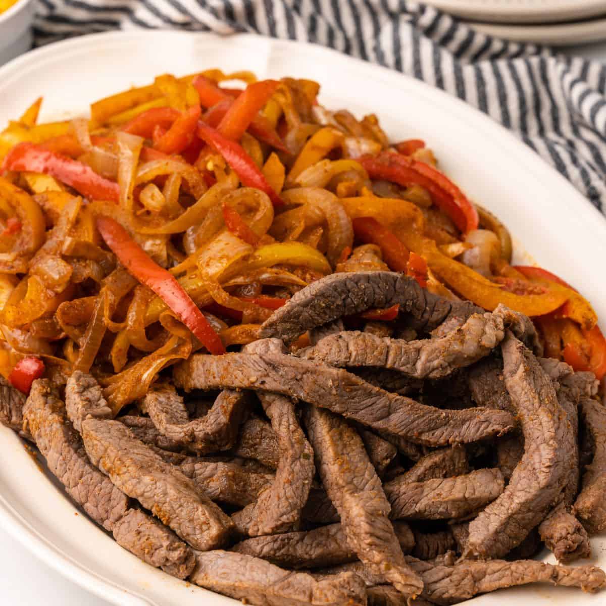 overhead picture of steak fajitas on a platter.