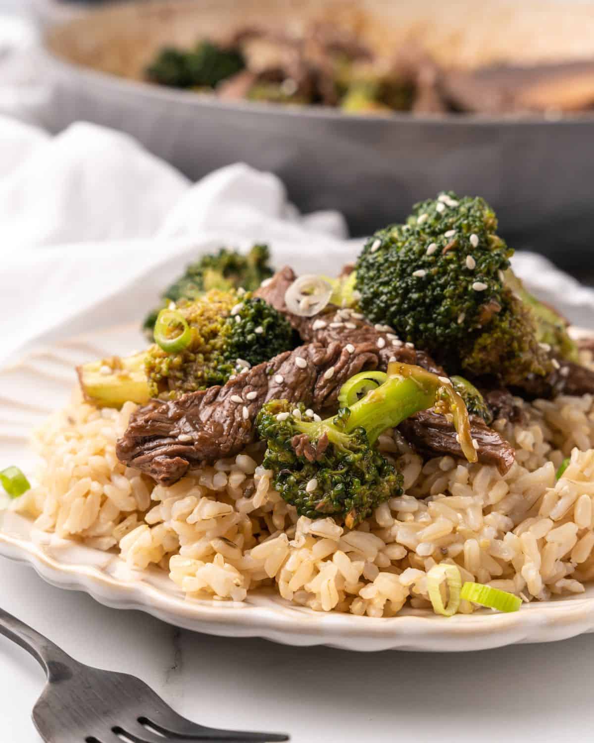 close-up picture of beef and broccoli on a place with brown rice.